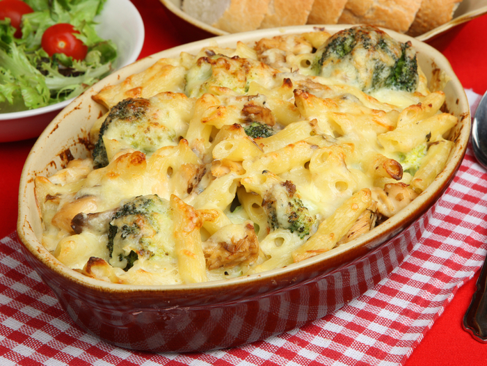 A delicious bowl of cheesy broccoli pasta bake with visible broccoli florets and a rich, creamy sauce.
