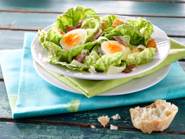 Caesar salad with soft boiled eggs and bacon