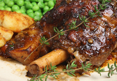 Roast leg of lamb with herb potatoes and peas